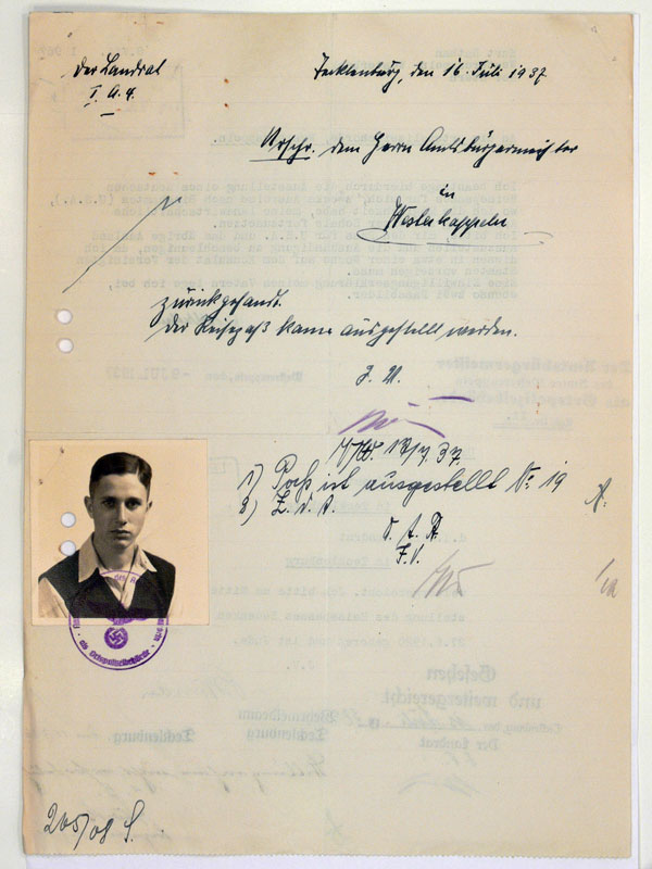 Hole-punched page with small passport photograph and handwritten data.
