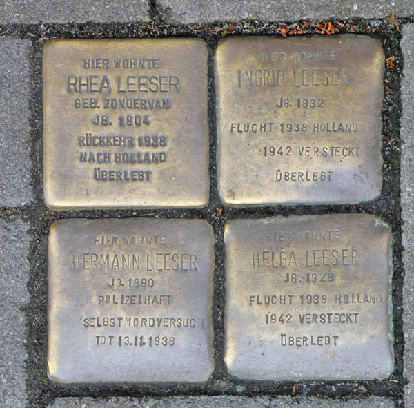 Four Stolpersteine close together in the ground. between 21 and 24: a Stolperstein in close-up.